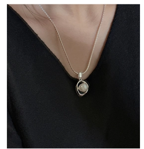 Close-up of minimalist S925 sterling silver necklace with pearl in irregular pendant