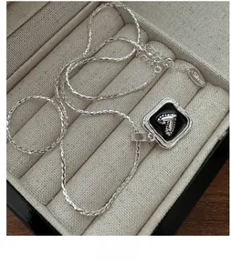 Macro shot of S925 sterling silver heart pendant with black enamel in a jewelry box