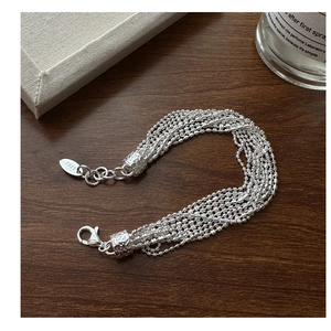 Close-up of S925 sterling silver multi-layer bead bracelet with lobster clasp on wood