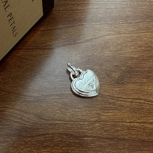 Pendentif coeur en argent S925 avec gravure Beckoning et zircone sur fond de bois