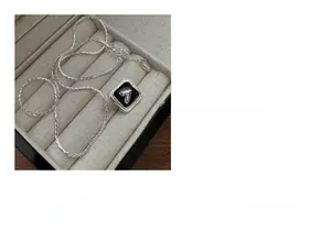 Detailed view of S925 sterling silver heart necklace on a soft beige velvet jewelry box