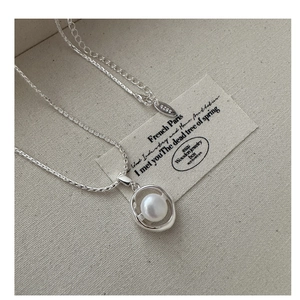 Close-up of S925 silver necklace featuring an oval pendant with a round white pearl