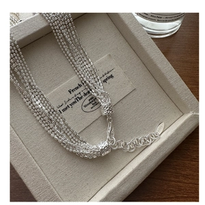 Close-up of S925 sterling silver multi-layer bead chain necklace with textured connector