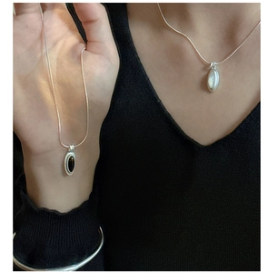 Detail of S925 silver necklace with oval black agate pendant and minimal metal cuff