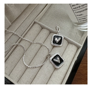 Macro view of S925 silver heart necklace with black enamel inlay in a jewelry box