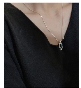 Close-up of S925 silver necklace with black oval pendant on a snake bone chain