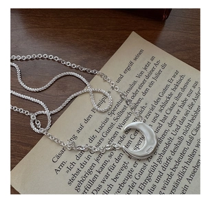 Detailed close-up of S925 sterling silver moon pendant with double layered chain design