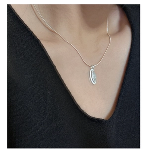 Close-up of S925 silver snake chain necklace with oval agate pendant on a model's neck