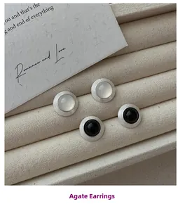 Détail de boucles d'oreilles agate rondes en argent avec une texture mate brossée fine