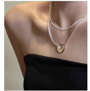 Detail of silver double-layered necklace featuring a sleek crescent moon pendant on model