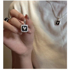 Close-up of S925 silver necklace featuring a square black enamel heart pendant and fine chain