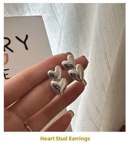 Macro detail of high-polished S925 sterling silver double heart stud earrings