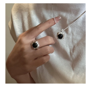 Detail of S925 sterling silver ring and necklace set with black onyx in lava texture