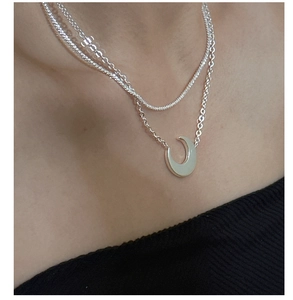 Detail of silver S925 double-layer necklace with polished moon pendant on model
