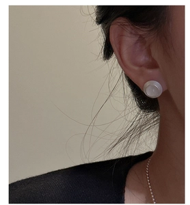 Détail d'une boucle d'oreille en argent S925 avec texture ronde et pierre de lune translucide