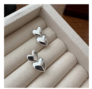 Detailed close-up of polished S925 sterling silver double heart earrings in a jewelry box