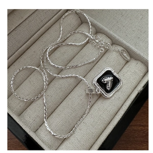 Detail of S925 sterling silver chain with square pendant featuring black enamel and number 7