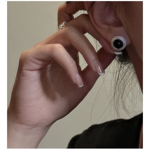 Gros plan d'une boucle d'oreille en argent S925 avec une pierre noire sur un mannequin