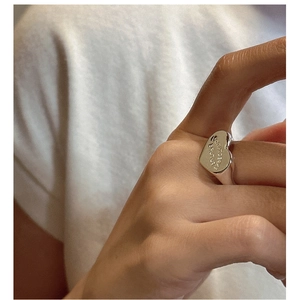 Detail view of S925 sterling silver heart ring with engraved Romantic lettering on finger