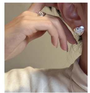 Close-up of heart-shaped S925 silver earrings and ring with EXCITATION engraving