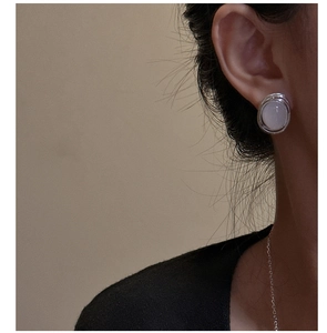 Close-up of S925 sterling silver hoop earrings with white agate stone worn by model
