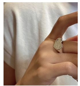 Detailed macro shot of an S925 silver heart signet ring with engraved English letters