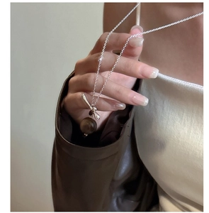 Vue détaillée d'un collier en argent S925 avec pendentif œil de tigre sur un mannequin