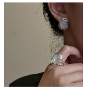 Detailed view of silver wire-wrapped bird nest earrings with oval moonstone gemstone