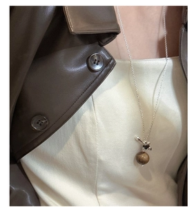 Détail du collier en argent S925 avec pierre oeil de tigre sur une veste en cuir