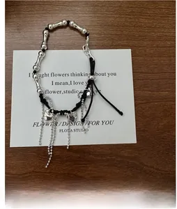 Detailed macro view of S925 silver heart charm bracelet with tassels and black woven rope