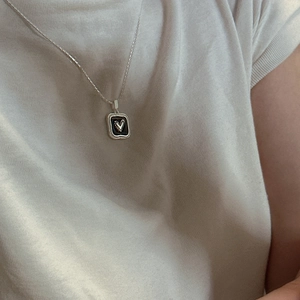 Elegant S925 sterling silver necklace with a black square heart pendant worn by a model
