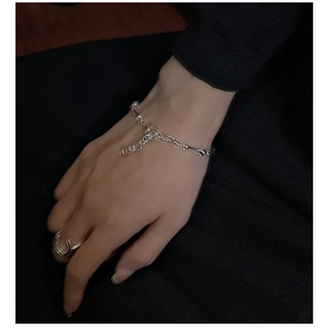 Macro detail of S925 silver beaded bone chain bracelet and horseshoe open ring on hand