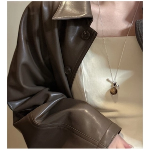 Détail du collier en argent S925 avec pierre oeil de tigre porté sur veste en cuir