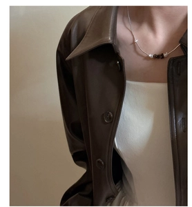 Detailed shot of S925 sterling silver chain necklace with brown beads on a model