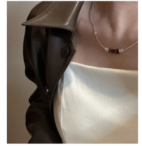 Detail of S925 silver necklace with brown tiger eye stone on a female model neck