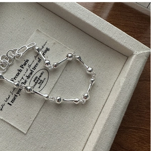 Macro shot of polished S925 silver link bracelet with organic bone-shaped texture details