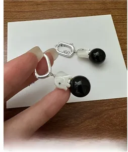 Close-up of S925 silver elephant earrings with agate beads on decorative card