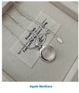 Macro shot of S925 silver agate necklace with adjustable clasp on cream fabric box