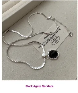 Vue rapprochée du collier en argent S925 avec onyx noir sur fond en lin vintage