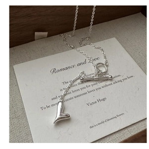 Dettaglio della collana a cuore in argento S925 con chiusura a levetta su legno