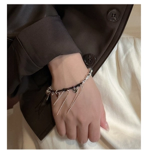 Detail of S925 silver heart bracelet with long tassels on a wrist for fashion styling