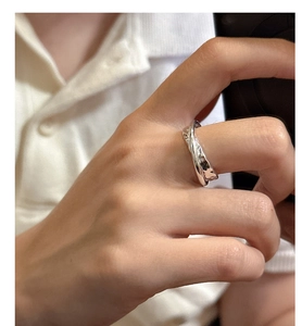 Detail of a minimalist silver S925 ring featuring a unique hammered texture and double-layered design