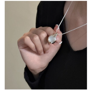 Close-up of S925 silver necklace featuring a translucent white agate stone on a model