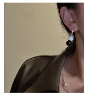 Close-up of S925 sterling silver elephant earring with black onyx bead on a model