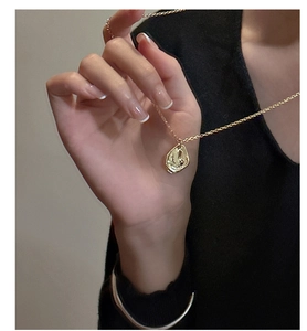 Gros plan d'un collier en argent s925 doré avec un pendentif texturé effet lavé