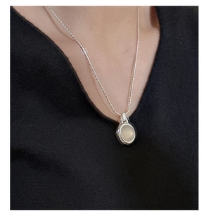 Close-up of elegant S925 sterling silver necklace with white agate pendant on model
