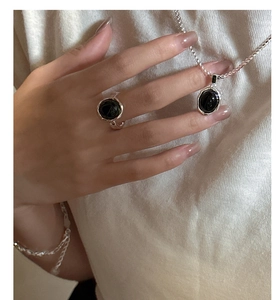 Gros plan d'un ensemble collier et bague en argent S925 avec onyx noir sur modèle
