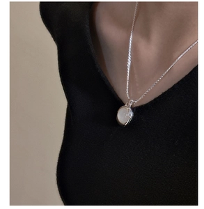Detail of S925 sterling silver necklace featuring a translucent white agate stone on a model