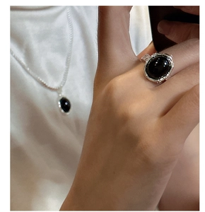 Vue détaillée du pendentif agate noire sur chaîne de perles avec texture argentée mate