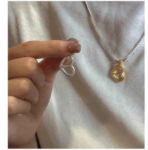 Close-up of S925 sterling silver hollow heart pendant on a fine metal chain